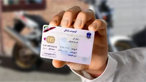 فردی که یک گواهینامه رانندگی موتور سیکلت در دست دارد